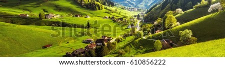 Scenic panoramic landscape of a picturesque green mountain valley in spring. Historic village with blossoming trees and traditional houses. Germany, Black Forest. Colourful travel background. Royalty-Free Stock Photo #610856222
