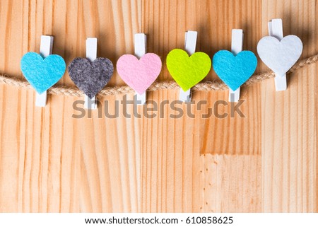 Colorful hearts on twine on natural wooden background. Copy space on the bottom.