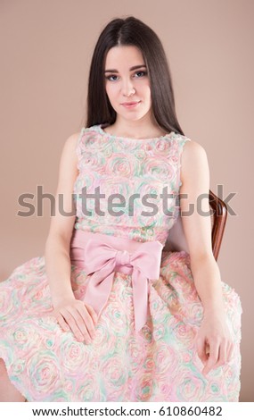 Beautiful young woman in pink dress, studio shooting