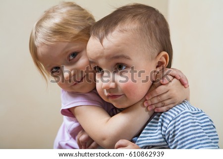 Little girl is hugging 2 years old boy
