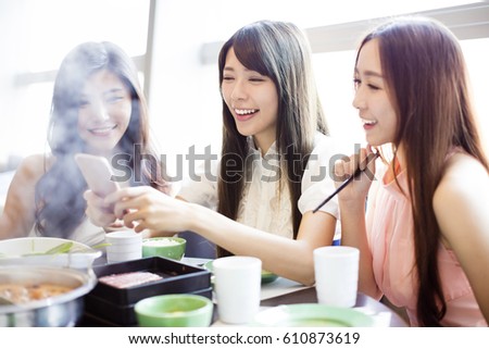 young Women group  Eating hot pot and taking picture by phone