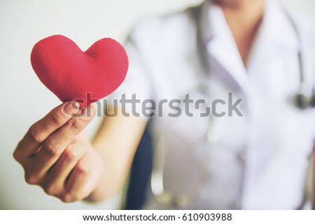 Red heart in nurse's hands. We care concepts.
