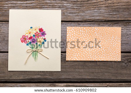 Greeting card with flowers on wooden background. Studio photo.