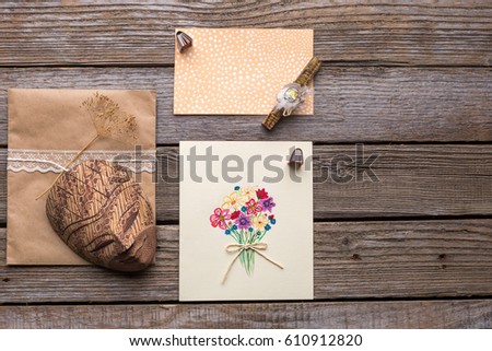 Envelope, postcard and mask on a wooden background. Studio photo