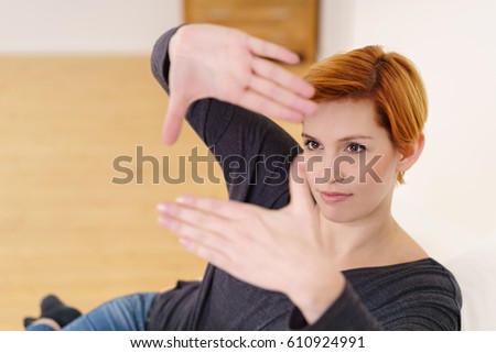 Young pretty auburn woman framing her face with hands