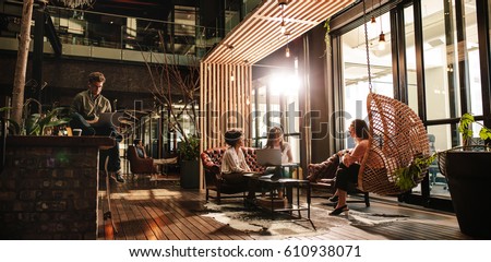 Wide angle shot of business people in modern office. Young men and women working in office lobby. Royalty-Free Stock Photo #610938071