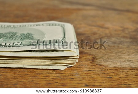 Heap of American money (US currency, USD) on the wooden background as a symbol of wealth