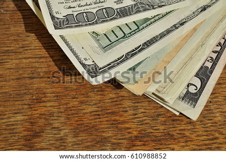 Heap of American money (US currency, USD) on the wooden background as a symbol of wealth