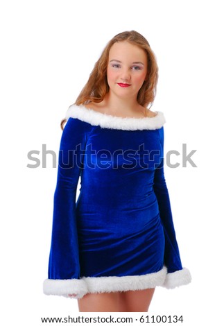 Shy teenage girl is standing and looking at the camera. She is wearing blue velvety dress decorated with white fluff.