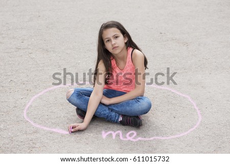Girl sitting on the ground and drawing personal space. Selective focus