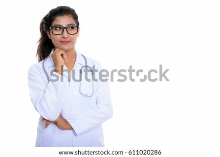 Studio shot of young beautiful Persian woman doctor thinking with eyeglasses isolated against white background