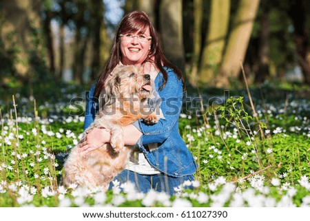 portrait picture of a young woman and her dog between thimbleweeds