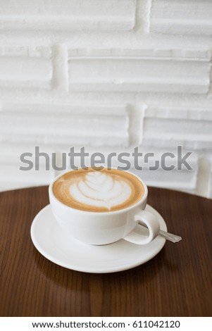 Latte coffee in white cup on wooden table