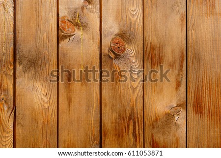 Row of tinted brown wooden boards with knots