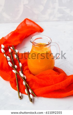 Jug with orange juice, near the ice