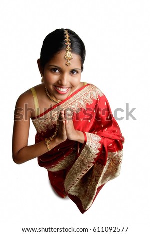 Woman in sari, standing with hands together, high angle view