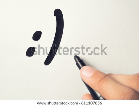 Smile is drawn on a piece of paper with a marker