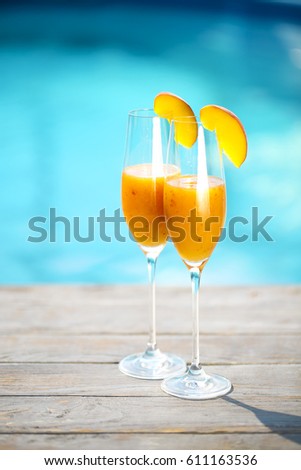 Champagne glasses with peach. Bellini cocktail. Summer pool party