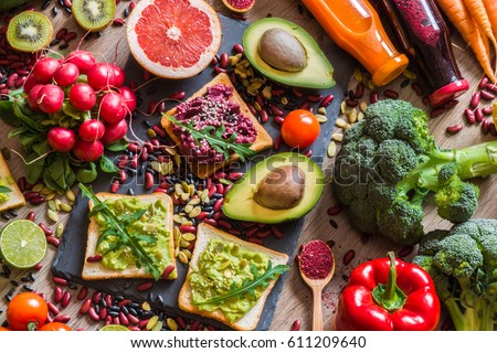 Healthy vegan food. Fresh vegetables on wooden background. Detox diet. Different colorful fresh juices. Royalty-Free Stock Photo #611209640