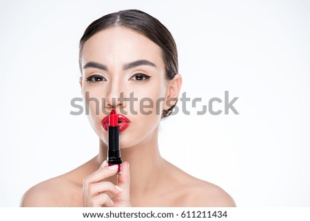 portrait of woman showing silence sign with lipstick isolated on white