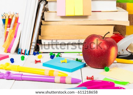 Back to school concept - school stationary and apple on the white wooden table