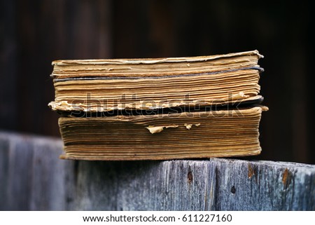 Old books against a wooden wall close up