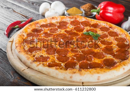 Pepperoni pizza. Macro. Creative author's pizza. This is a series of different pizzas. The main types of pizza are photographed from one angle. Royalty-Free Stock Photo #611232800