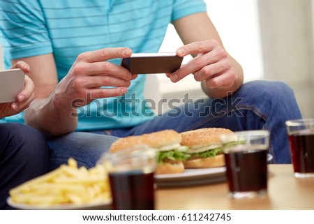 people and technology concept - group of friends with smartphones taking picture of food at home
