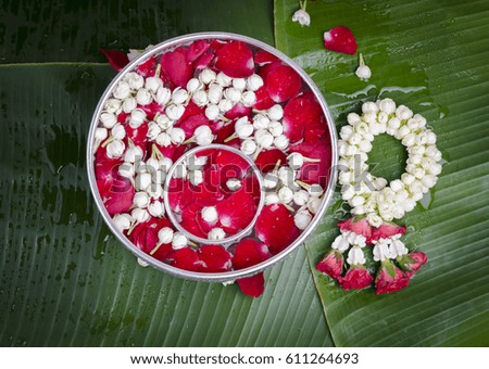 Jasmine and roses in silver bowl on leaves of banana background ,Songkran festival in Thailand
