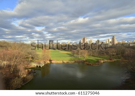 Cloudy sky and bid field of city lake landscape in Central Park in New York City USA