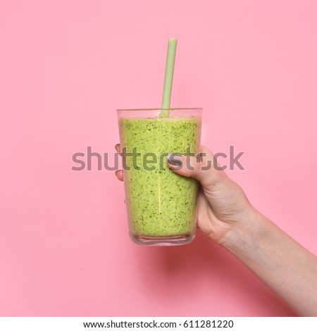 Woman hand holding smoothie shake against pink wall. Drinking green healthy smoothie concept.
 Royalty-Free Stock Photo #611281220