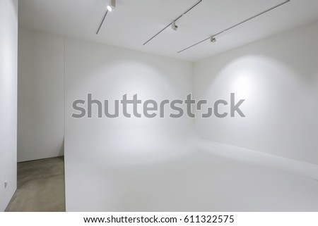 white design studio with horizontal wall for studio photography, white handrail, lighting, concrete bottom.