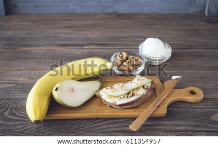 Set of products for making sandwiches from bread and ripe fruit pear banana , healthy Breakfast. Dark wooden background. Copy space