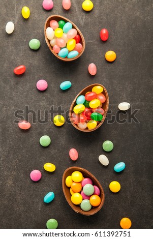 Easter chocolate eggs with colorfull candies on chalkboard.