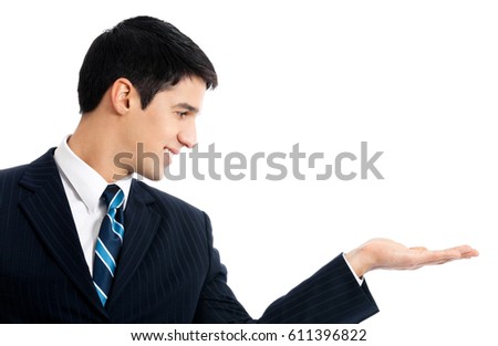 Happy smiling young businessman showing something or blank area for sign or copyspase, isolated over white background. Success in business and education concept.