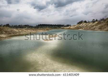 A gloomy day over a lake in the place of a sand pit.