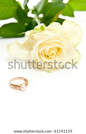 Golden ring with pearl and rose on white background