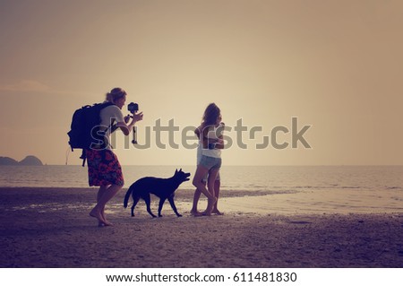 Photographer takes photo of young couple on the beach, vintage tone