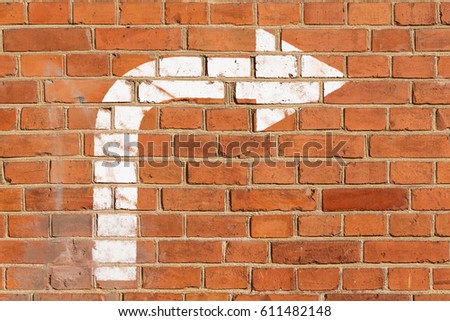 Brick wall with a driving direction sign