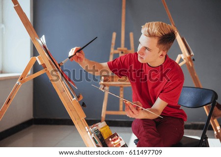 young artist paints a picture in the studio.