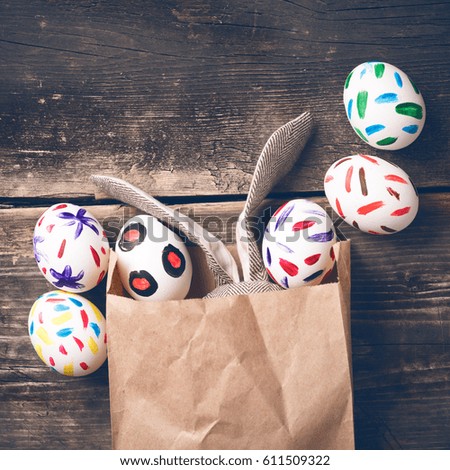 Easter bunny in a paper bag on old boards. Rabbit. Old board background. Easter ideas. Easter eggs. Space for text. Image in trendy toning.