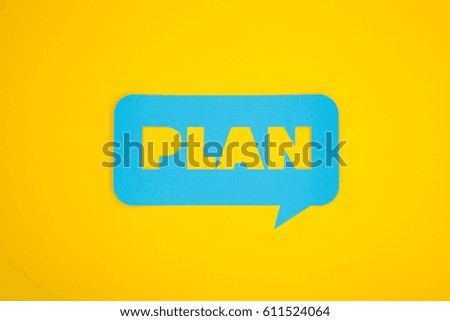 The plan word cut in the blue cardboard cloud on the yellow background from above. 