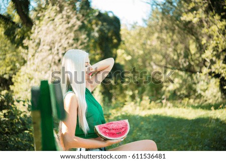 pretty girl outdoors eating fresh watermelon