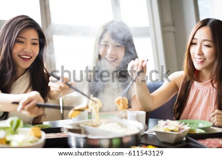 happy young Women group  Eating hot pot  Royalty-Free Stock Photo #611543129