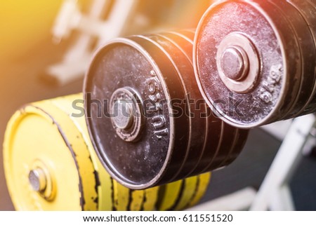 Close up of barbel weights in the gym. Gym equipment. Iron heavy plates stacked. Lens flare in background.