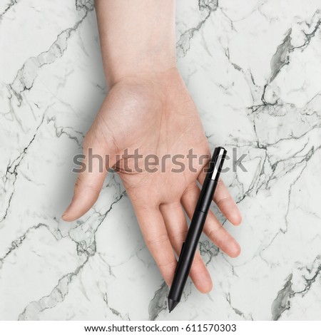 Male hand holding a graphic tablet stylus, isolated with clipping path on marble background