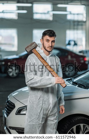 Car mechanic with a hammer