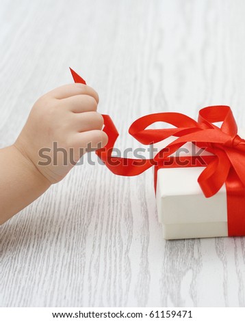 Little hand of the child opening a gift