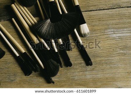 Makeup brushes with leather bag on rustic table