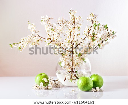 branches of a blossoming apple tree in a glass vase with water